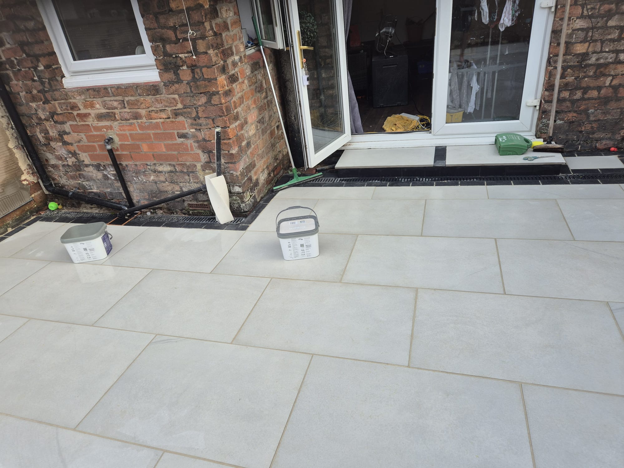 Grey porcelain patio with linear drainage channel and neat edging