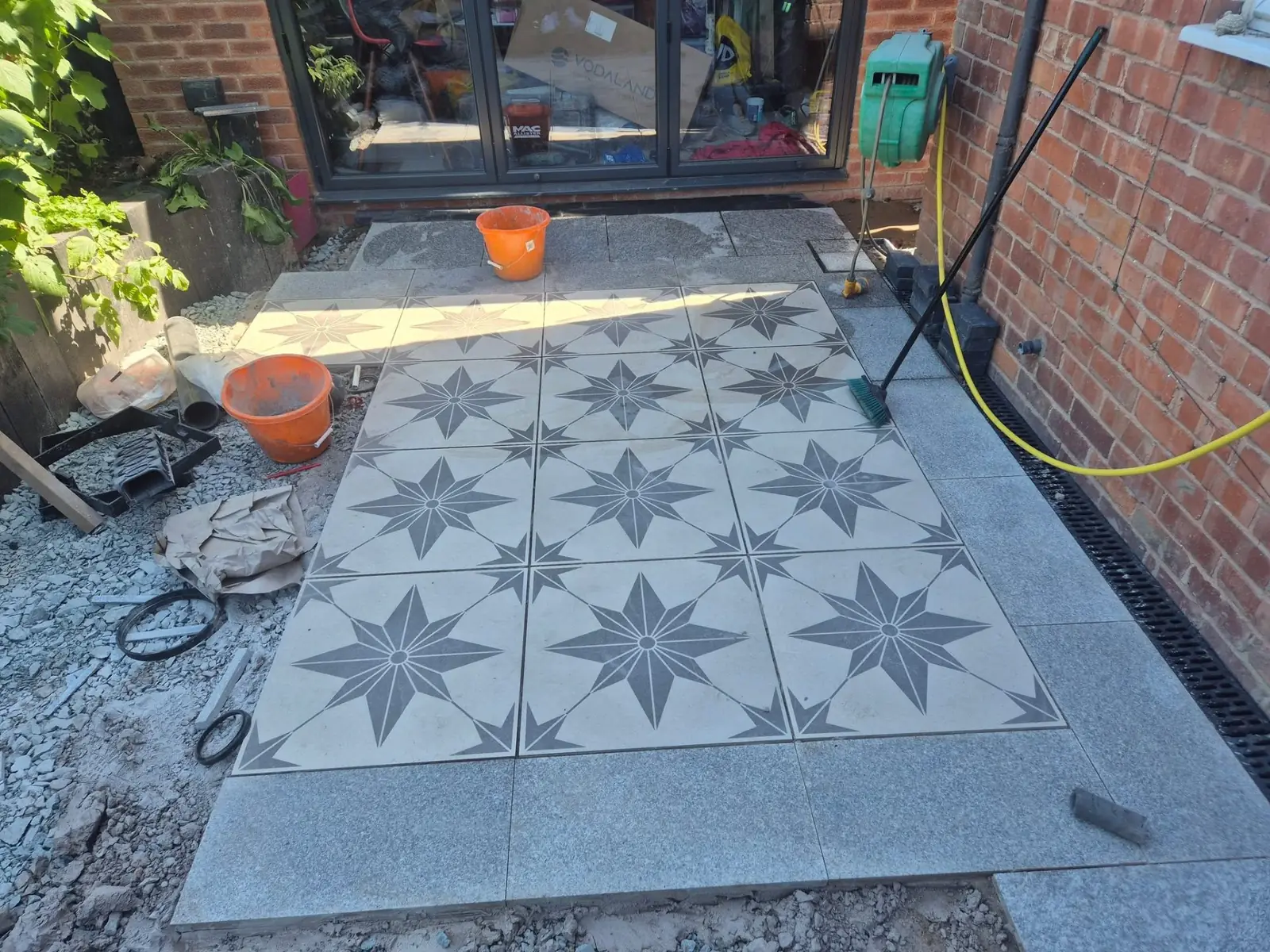 Decorative star-pattern feature tiles set into the patio