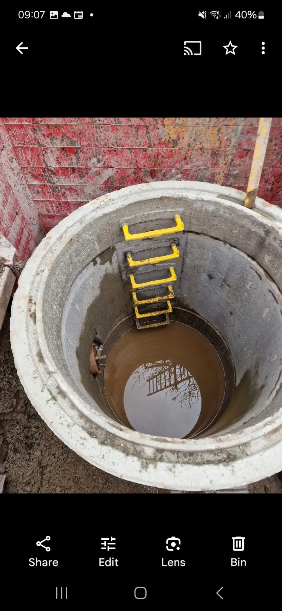 A deep concrete inspection chamber with step irons, built during drainage groundworks