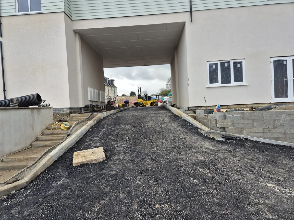 A newly surfaced tarmac driveway with kerbs, compacted and rolled