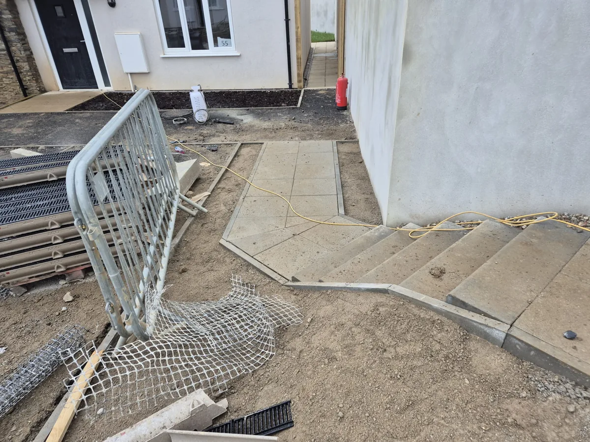 Concrete steps with paving and a channel drain set in at the threshold