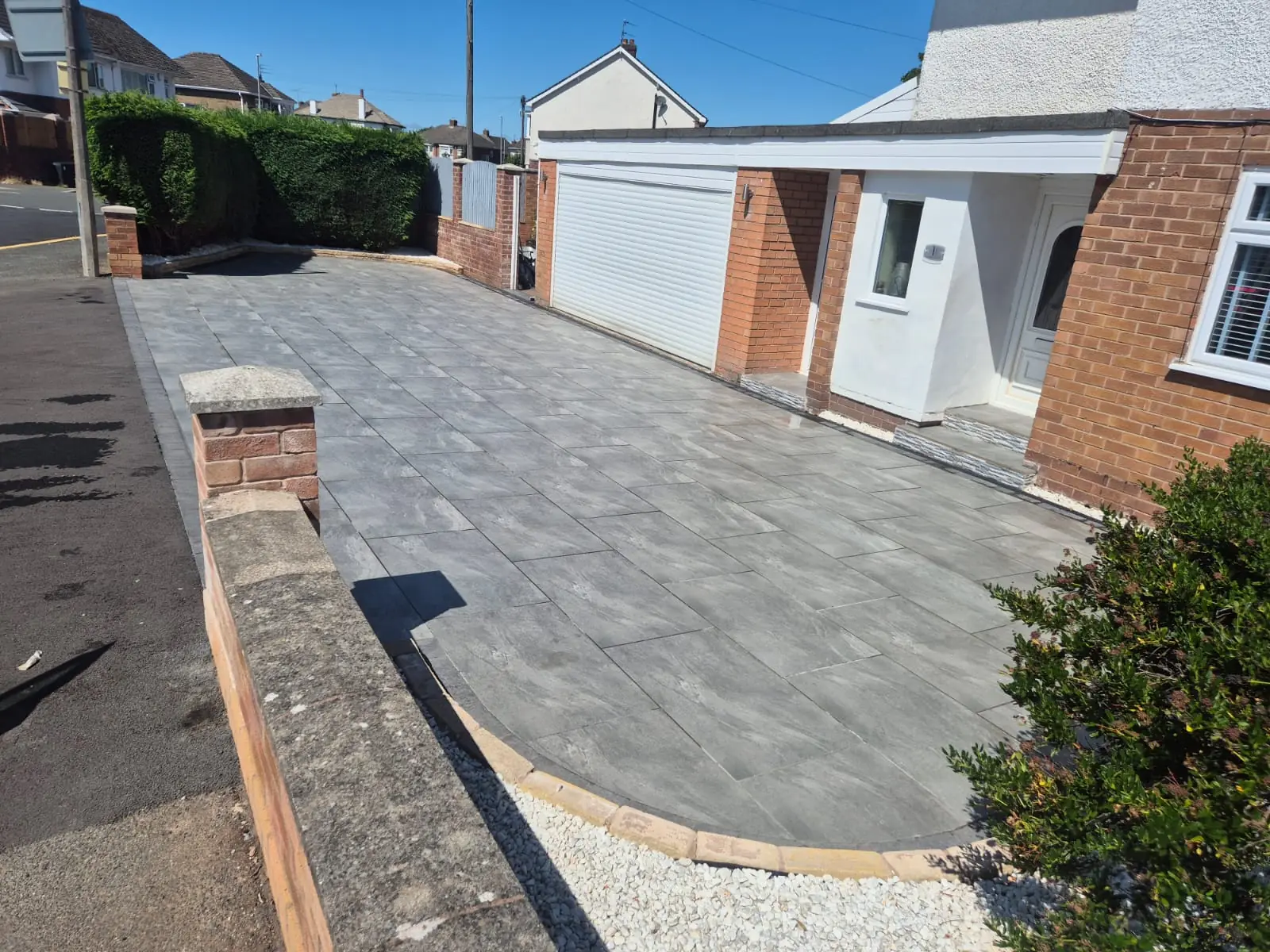 New slate-effect porcelain driveway with curved brick edging