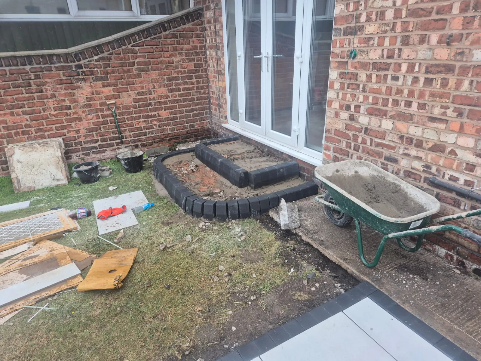 setting kerbs and edging with a barrow of mortar on a Wallasey patio job