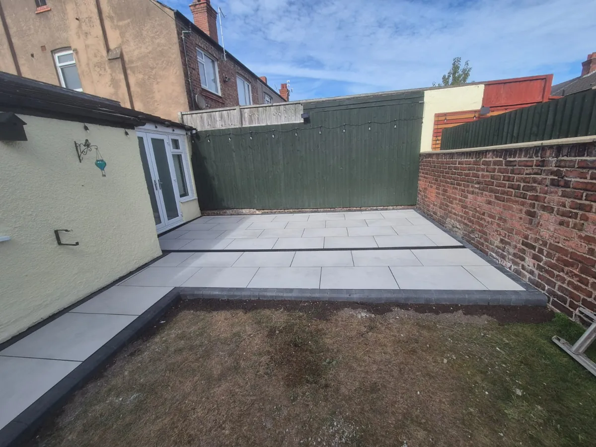 Finished white porcelain patio in Wallasey with dark coping border and linear drainage channel