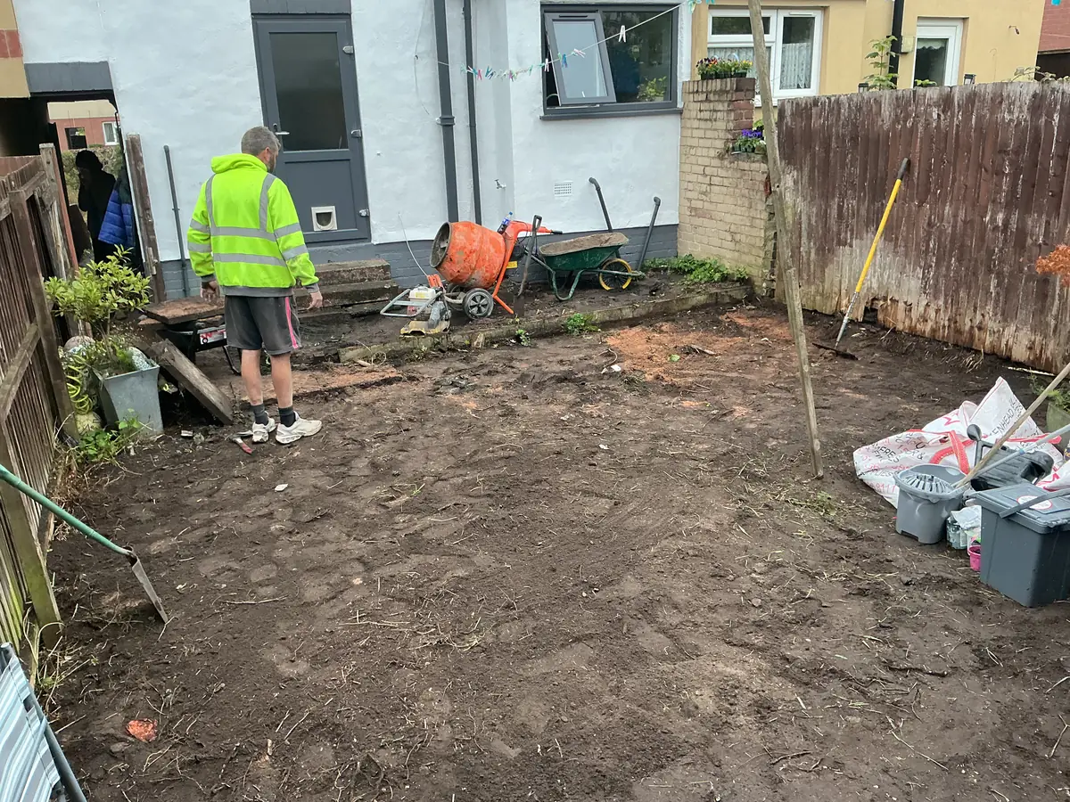 Birkenhead rear garden with the old surface removed and the area excavated back to soil, cement mixer and tools on site ready to build the base