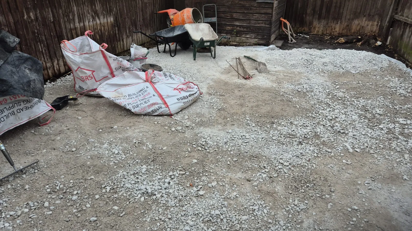A compacted stone sub-base laid and levelled over a membrane across the Birkenhead rear garden, ready for laying