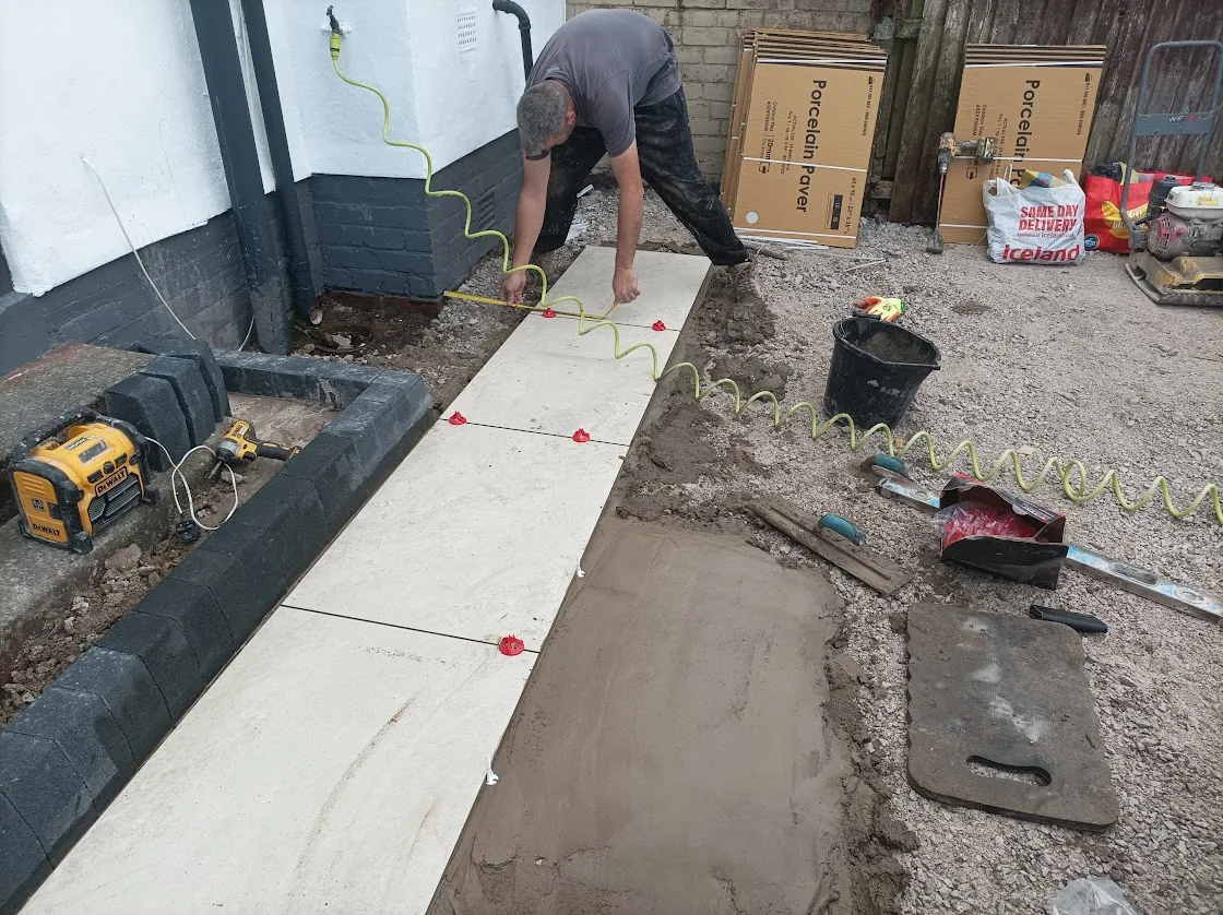 Charcoal block edging laid to the perimeter and the first porcelain slabs set out on a mortar bed in Birkenhead