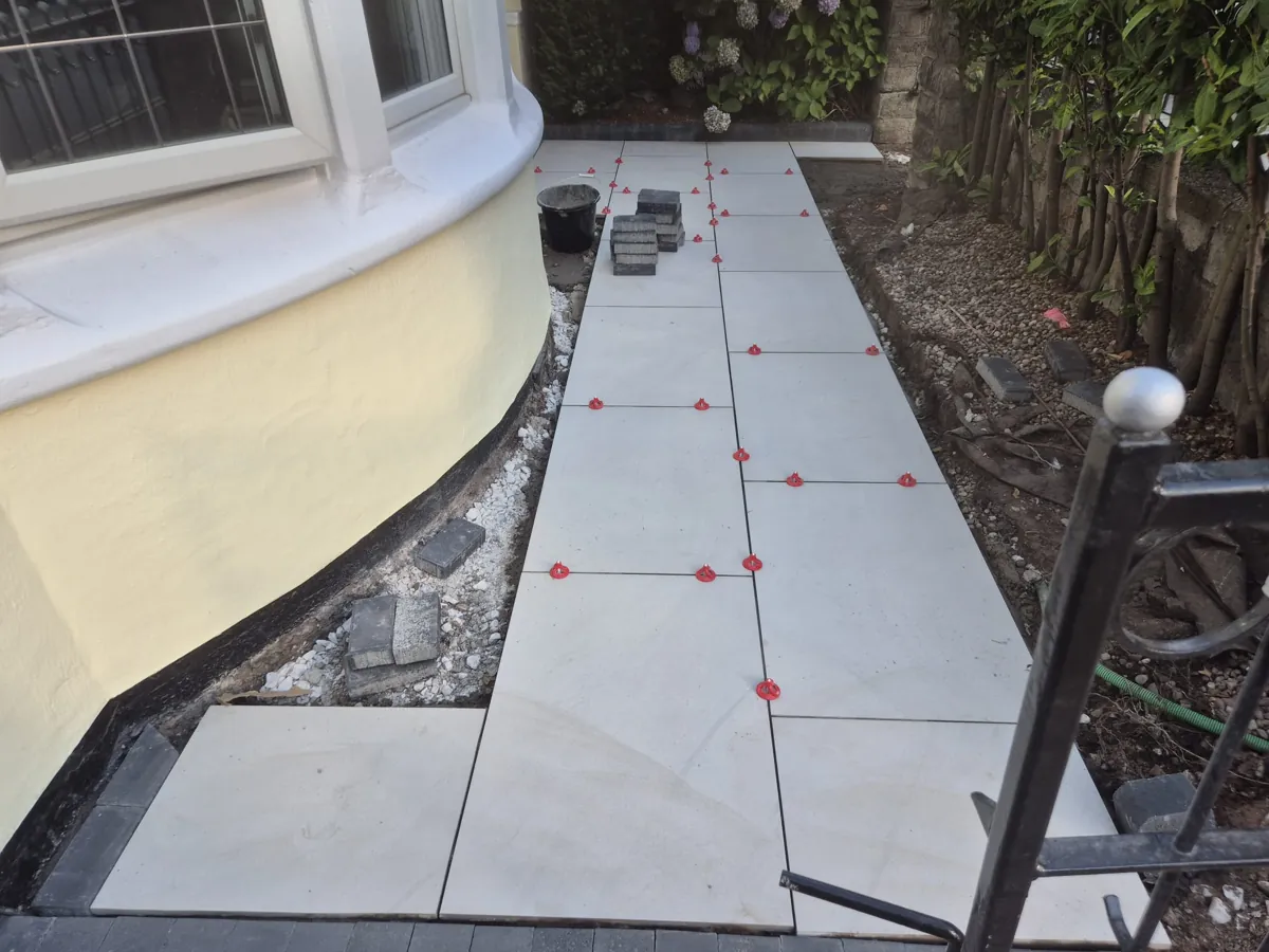 laying porcelain paving with red levelling spacers on a Wirral path